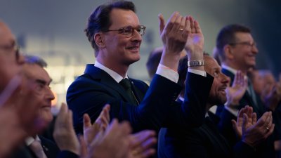 Ministerpräsident Wüst und andere menschen applaudieren